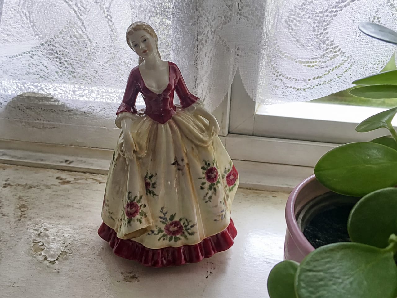 Vintage porcelain figurine on a windowsill, demo
