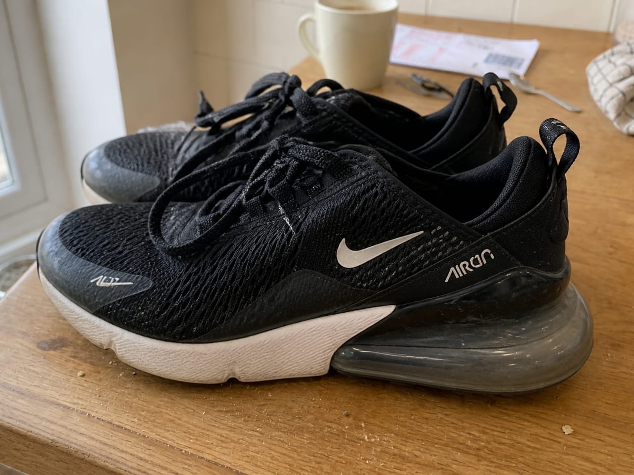 Side-angle phone photo of the same Nike trainers, demo